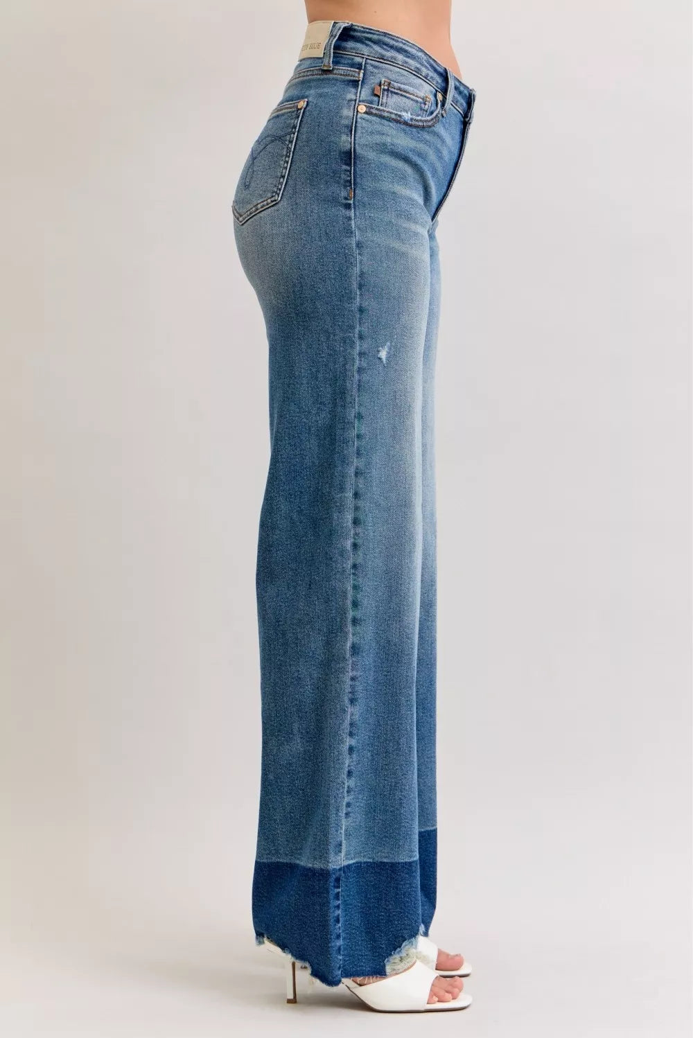 Blue jeans worn by a person on a white background
