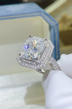Diamond ring held in a white glove with a blurred background