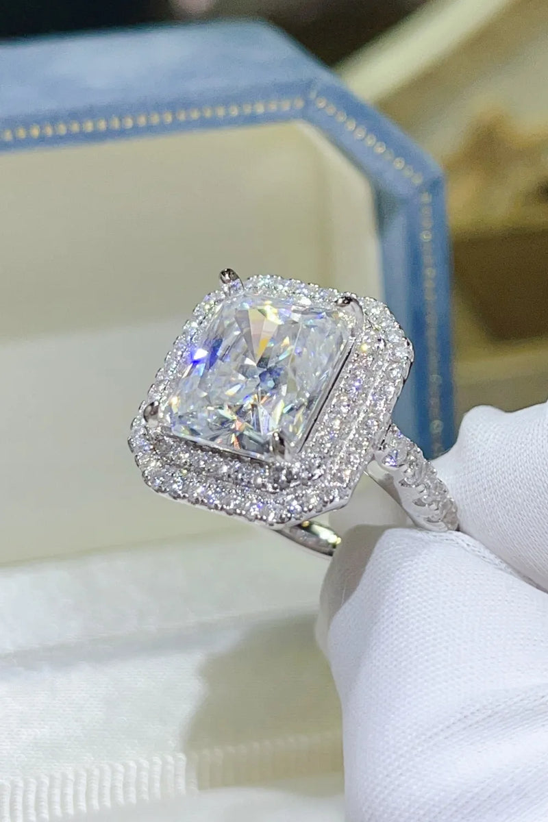 Diamond ring held in a white glove with a blurred background