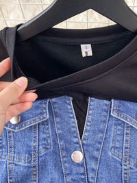 Black t-shirt on a hanger with a blue denim jacket in the foreground