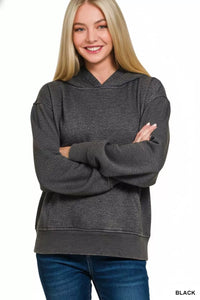 Woman wearing a gray hoodie with arms crossed on a white background