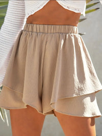 Beige shorts worn by a person with a blurred background