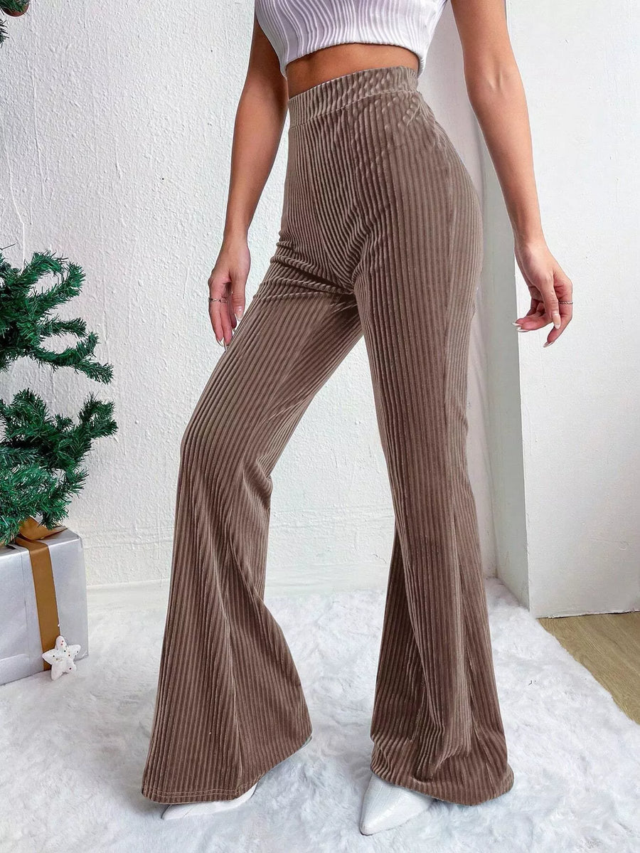 Brown ribbed flared pants worn by a person on a white background