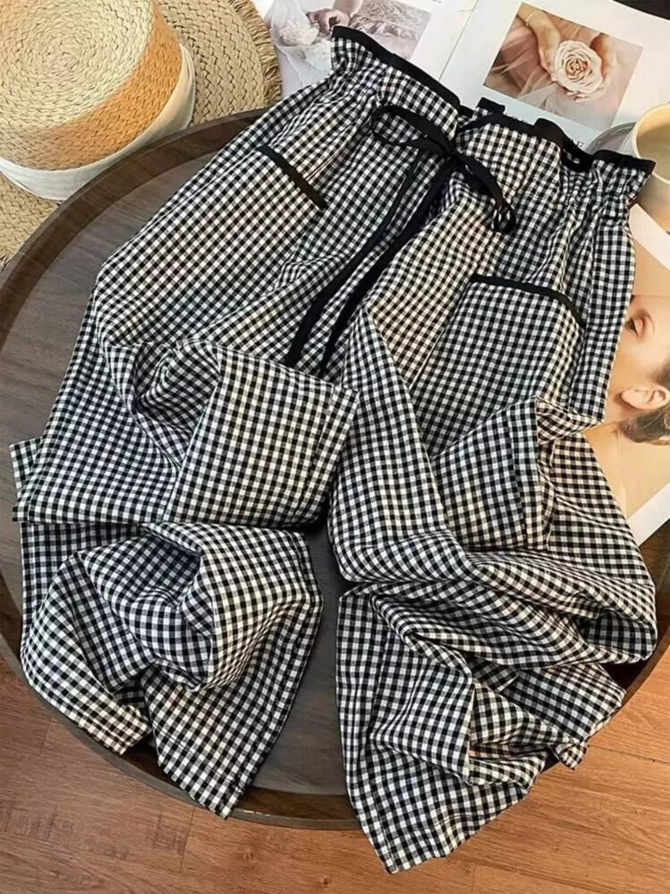 Black and white checkered pants on a wooden surface with a blurred background