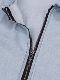 Close-up of a light blue denim jacket with a black zipper.