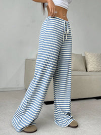 Blue and white striped pants worn by a person in a casual setting.