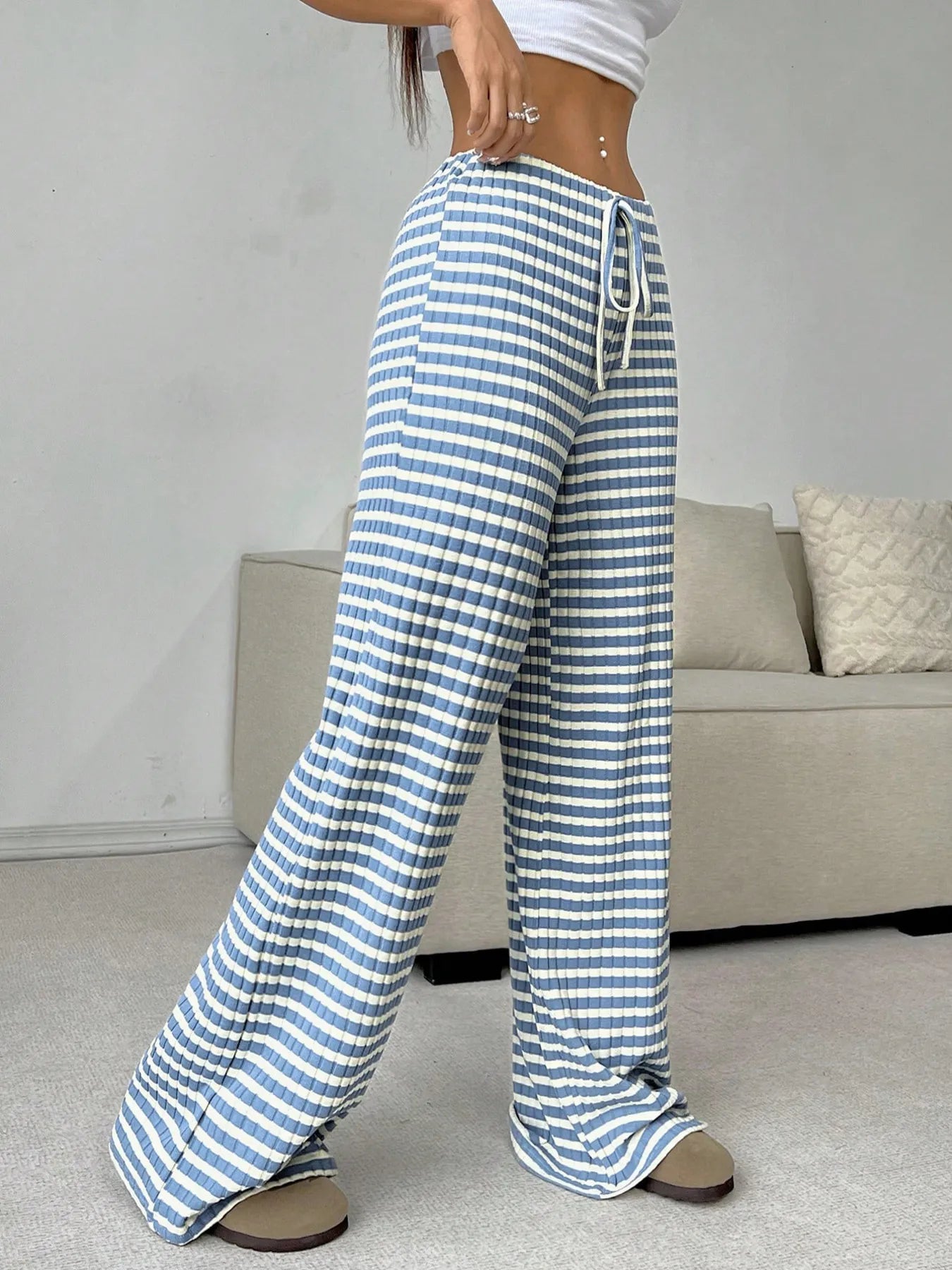 Blue and white striped pants worn by a person in a casual setting.