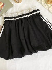 Black skirt with white lace waistband on a light background