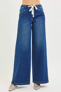 Blue wide-leg jeans with a white drawstring on a light gray background