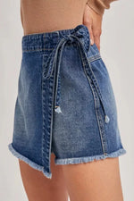 Denim skirt with tie waist on a plain background