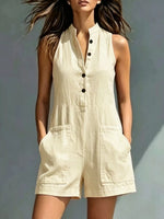 Woman wearing a beige sleeveless jumpsuit against a neutral background