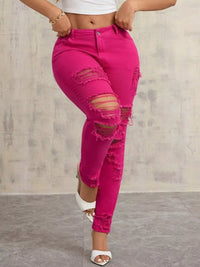 Person wearing bright pink ripped jeans against a neutral background
