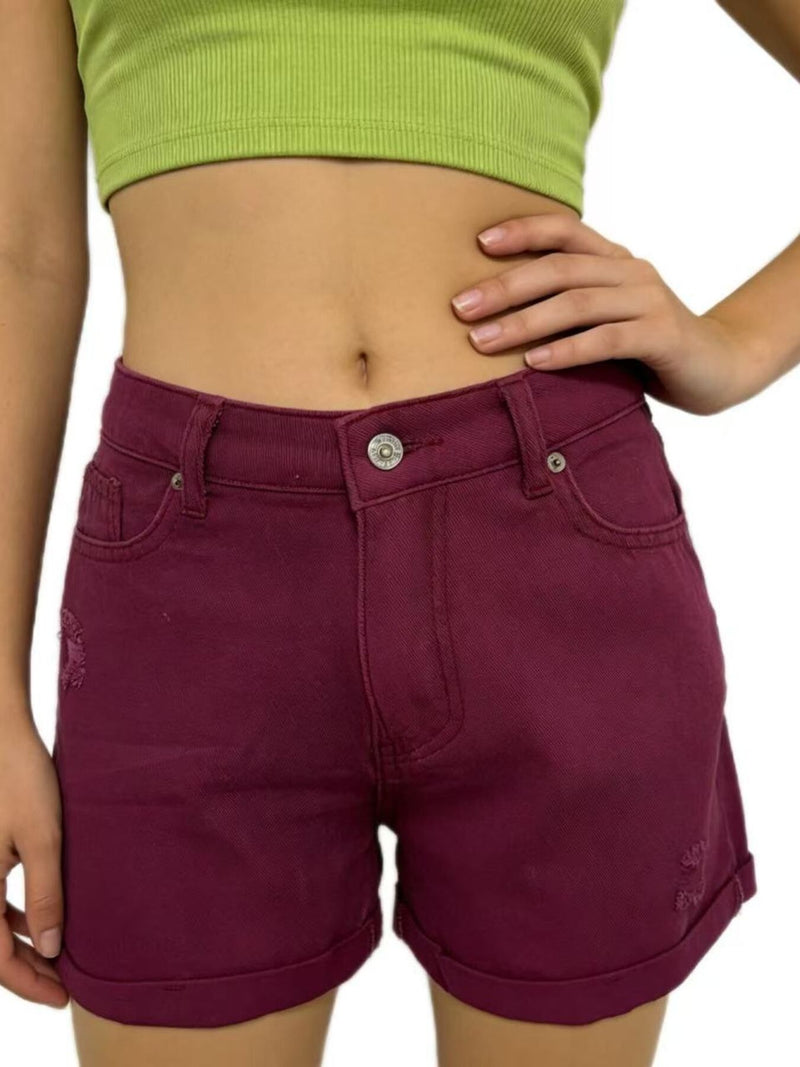 Person wearing maroon shorts and a green crop top on a white background