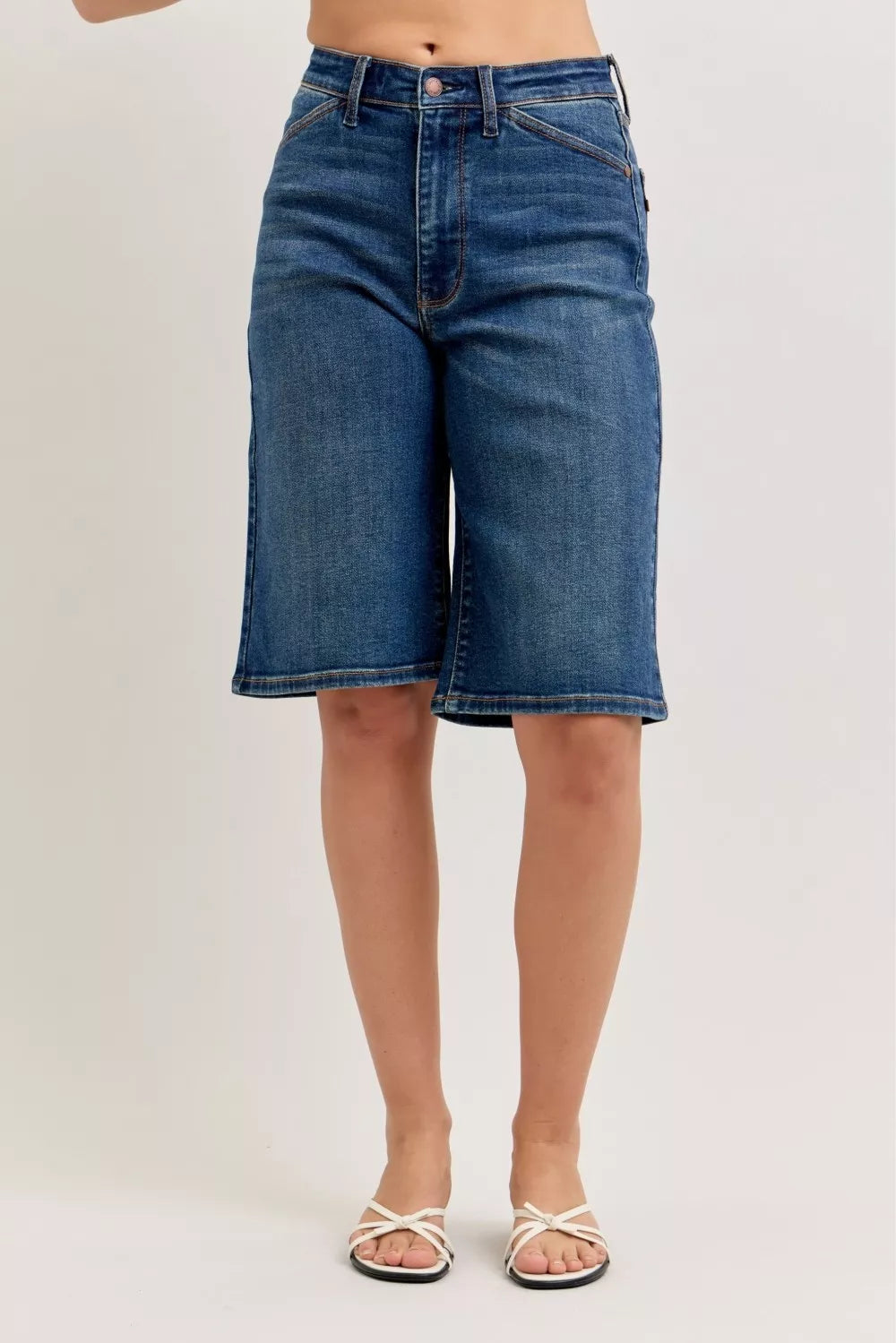 Person wearing blue denim shorts on a plain background