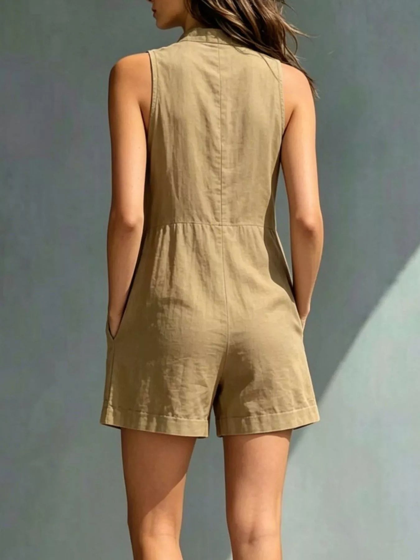 Woman wearing a beige romper against a gray background