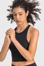 Woman wearing a black sports bra on a light gray background