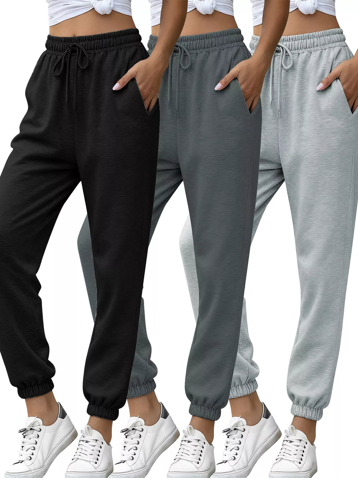 Three pairs of jogger pants in black, gray, and white with white sneakers.