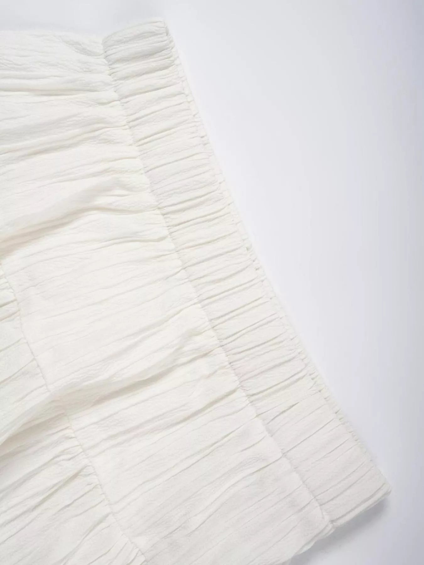 Close-up of a textured white fabric on a light gray background