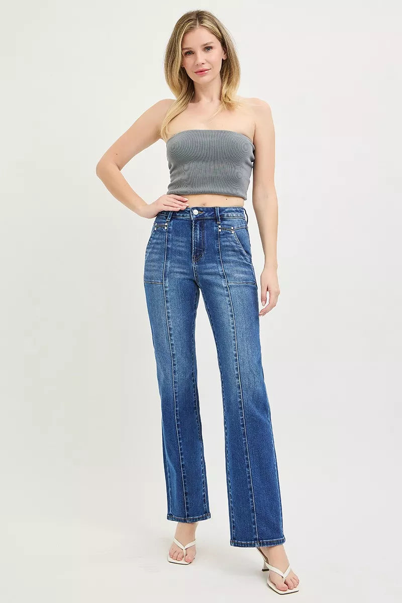 Woman wearing a strapless top and blue jeans on a white background