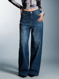 Person wearing blue wide-leg jeans on a gray background