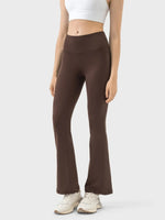 Brown flared pants worn by a person on a white background