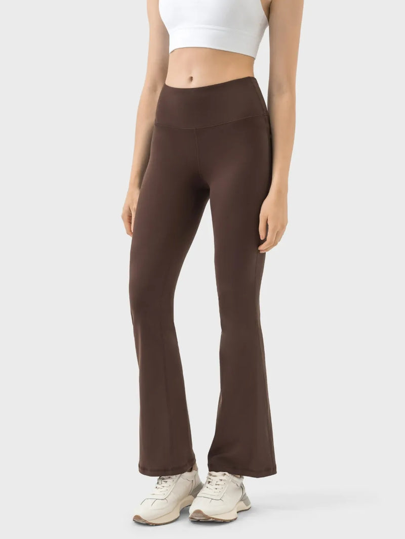 Brown flared pants worn by a person on a white background