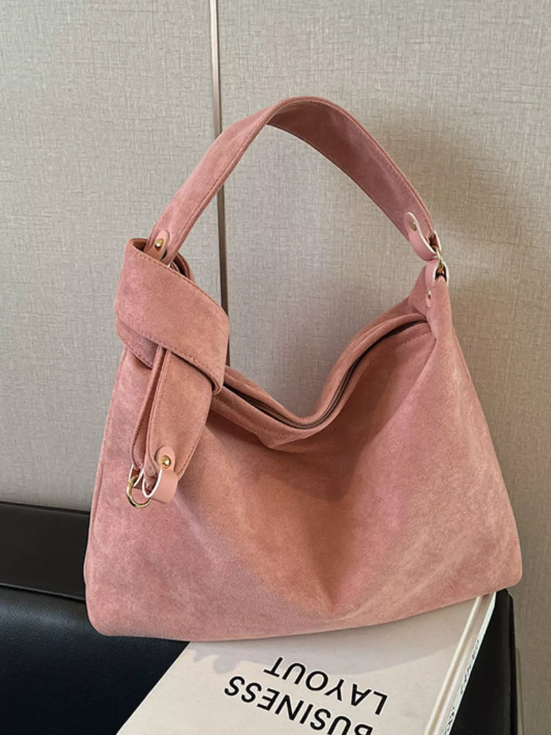 Pink handbag on a surface with a neutral background