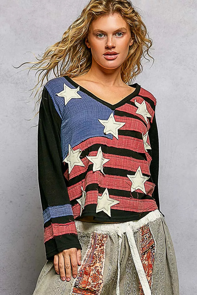 Woman wearing a colorful sweater with star patterns against a gray background