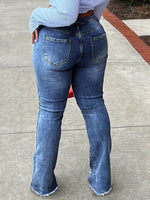 Person wearing blue jeans on a sidewalk