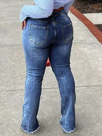 Person wearing blue jeans on a sidewalk