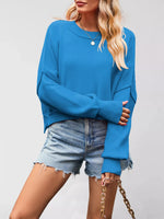 Person wearing a blue sweater and denim shorts on a plain background