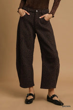 Person wearing brown patterned pants on a beige background