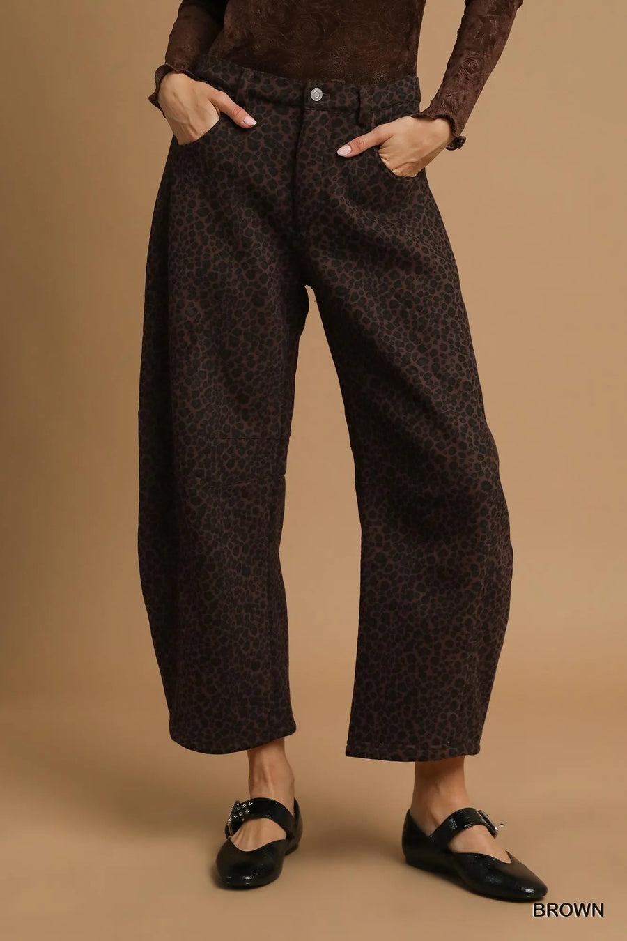 Person wearing brown patterned pants on a beige background