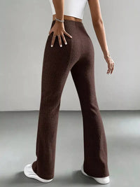 Brown ribbed pants worn by a person on a gray background