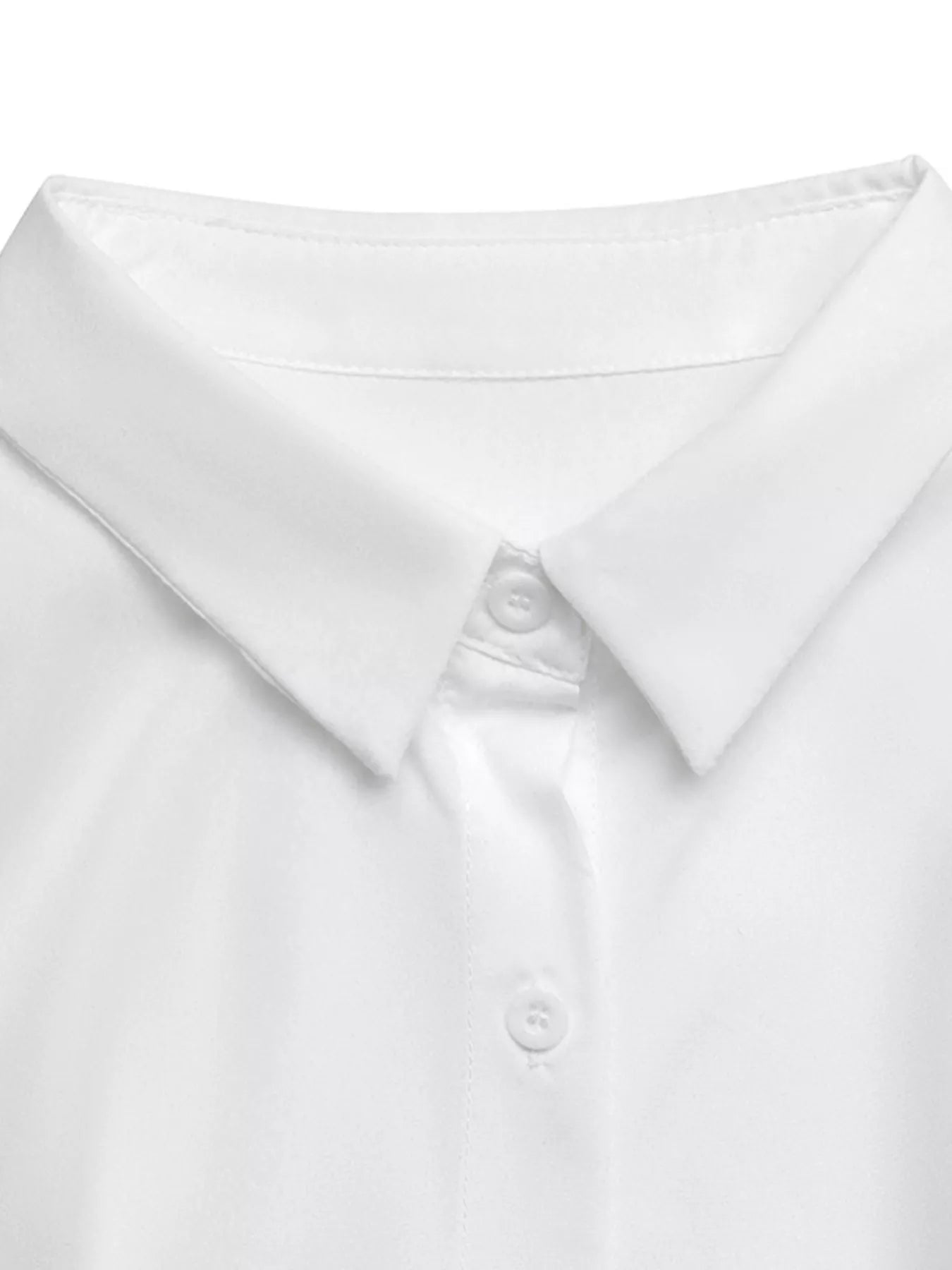 Close-up of a white shirt with a collar and button on a white background