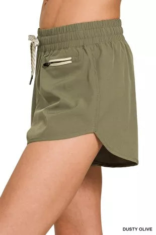 Green shorts worn by a person on a white background
