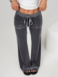 Gray wide-leg pants with a white top on a plain background