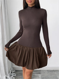 Brown dress with long sleeves and a flared skirt on a plain background