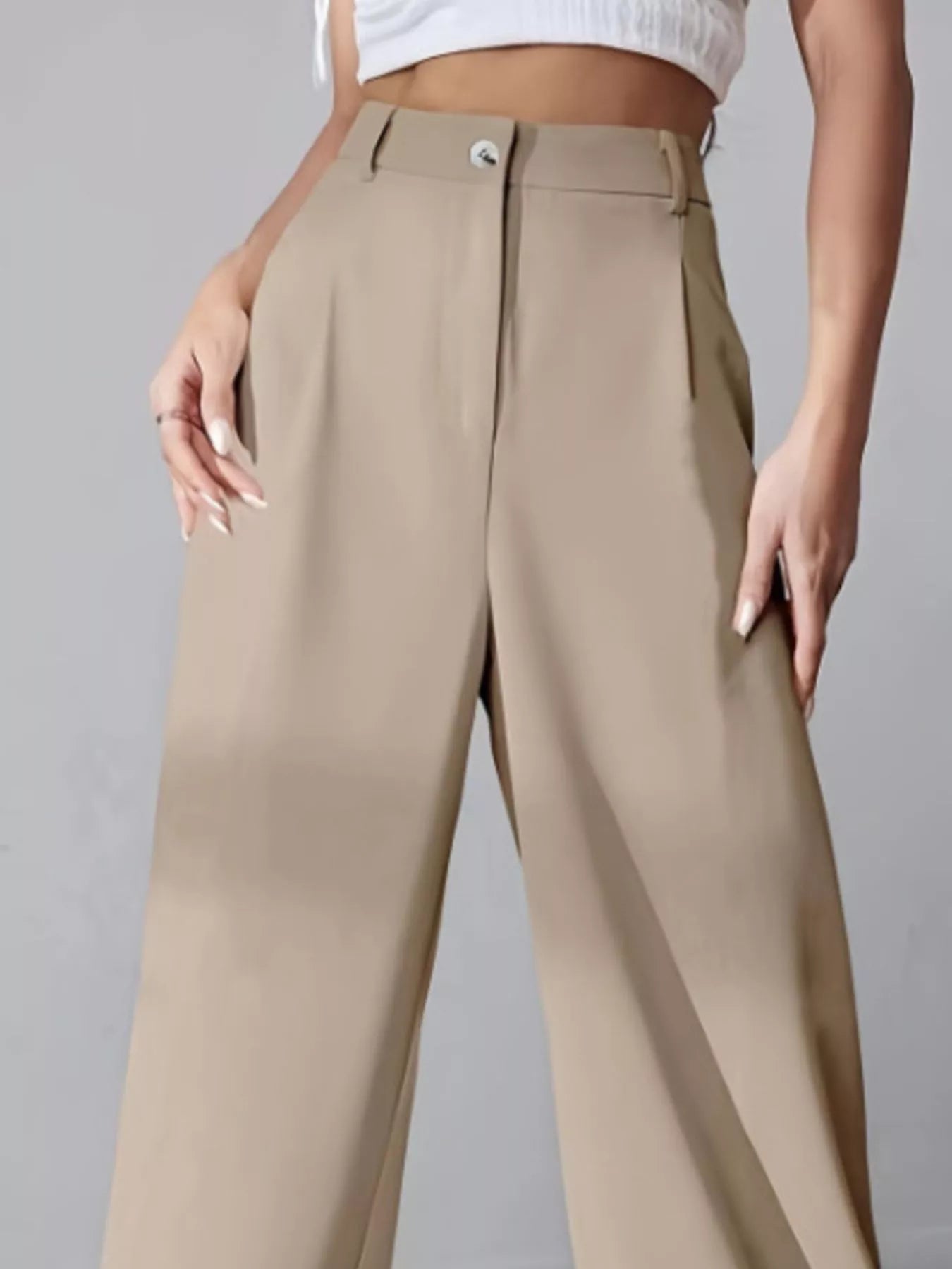 Beige pants worn by a person on a gray background