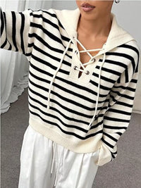 Black and white striped hoodie with lace-up front worn by a person.