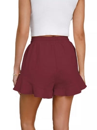 Maroon shorts worn by a person on a white background