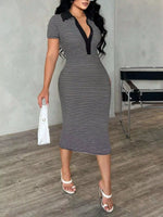 Woman wearing a black and white striped dress with a deep neckline in an indoor setting.