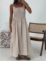 Person wearing a beige striped dress in a minimal indoor setting.