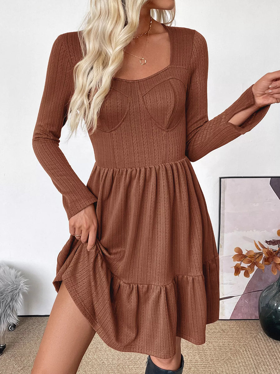 Woman wearing a brown ribbed dress with long sleeves in an indoor setting.