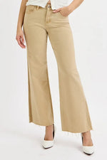 Person wearing beige wide-leg jeans on a white background