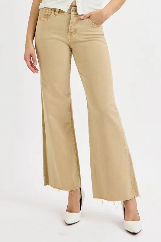 Person wearing beige wide-leg jeans on a white background