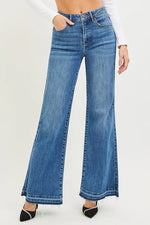 Blue flared jeans worn by a person on a white background