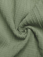 Close-up of green textured fabric with a grid pattern