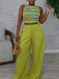 Person wearing a colorful striped top and bright green pants in an indoor setting.