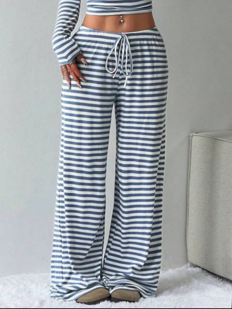 Person wearing blue and white striped pants with a gray background